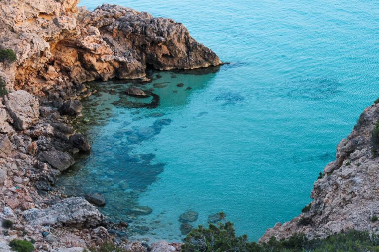 The bay of Cala Tarida with rock formations and unique turquoise water