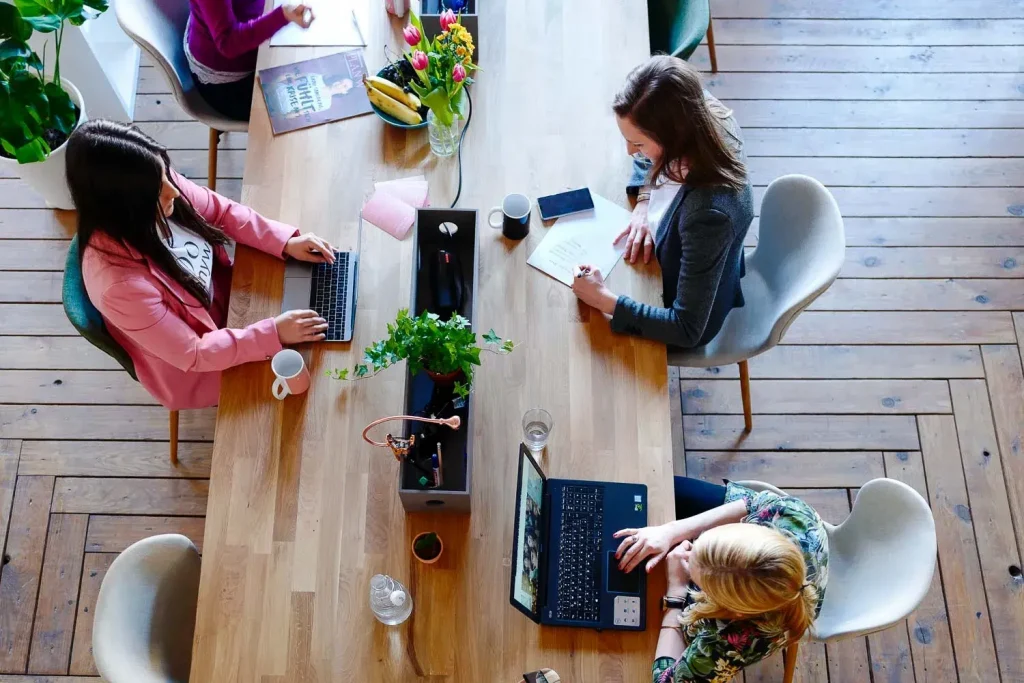 Three people sharing a dask in a coworking space in Athens Greece - Europe Workation