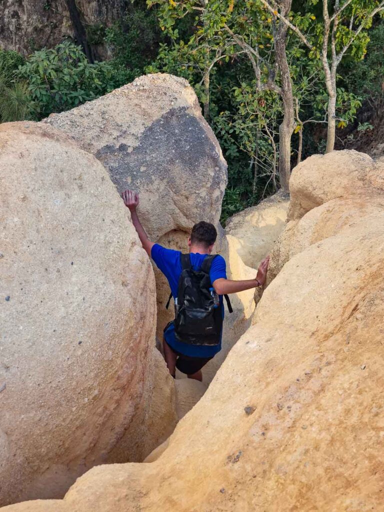 Exploring Pai Canyon in Thailand: A Guide to the Most Stunning Natural Wonder 6 Our friend trying to squeeze through the narrow paths of Pai Canyon in Thailand