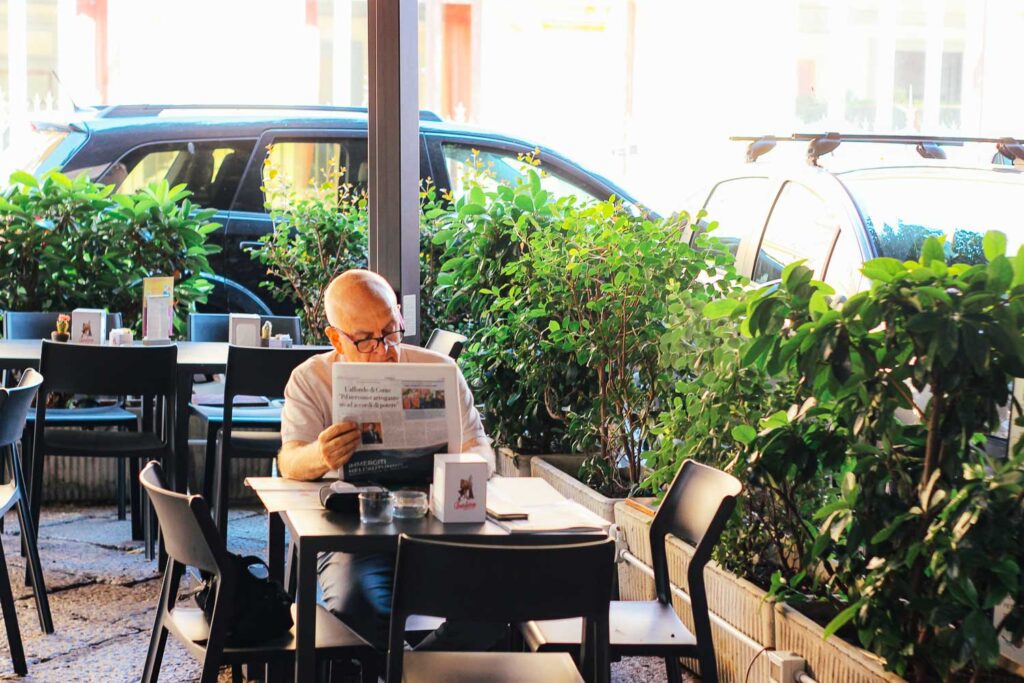 Old man reading the newspaper at a bar in Palermo for breakfast